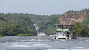 A boat cruise on the Nile River near Murchison Falls, surrounded by lush vegetation and rocky cliffs