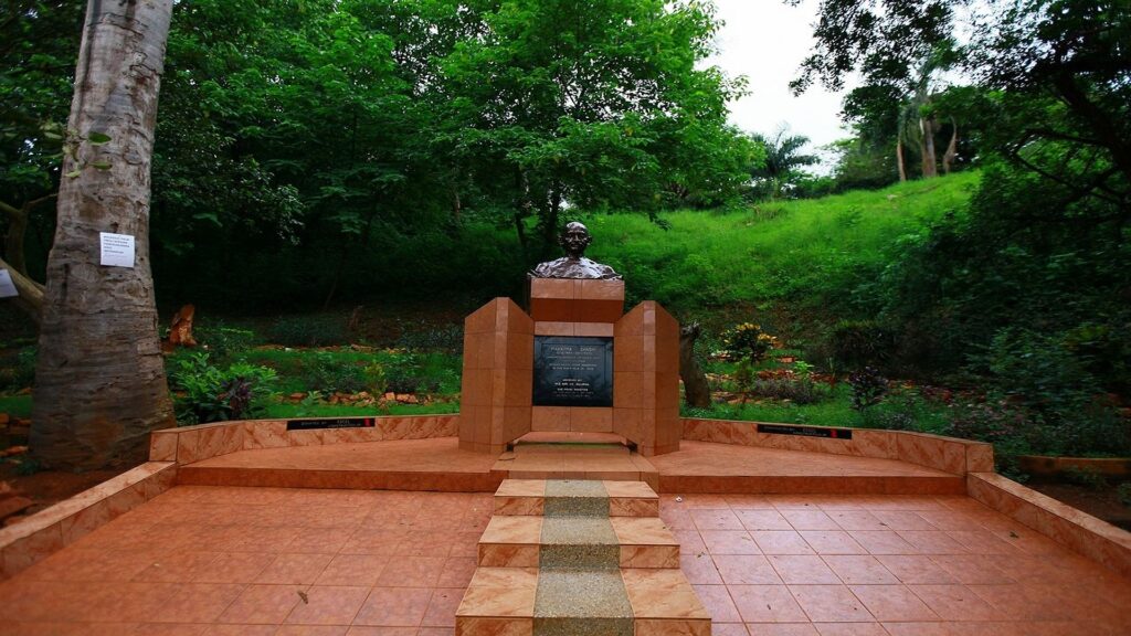 A statue of Mahatma Gandhi standing in a serene pose, located in Jinja, Uganda.