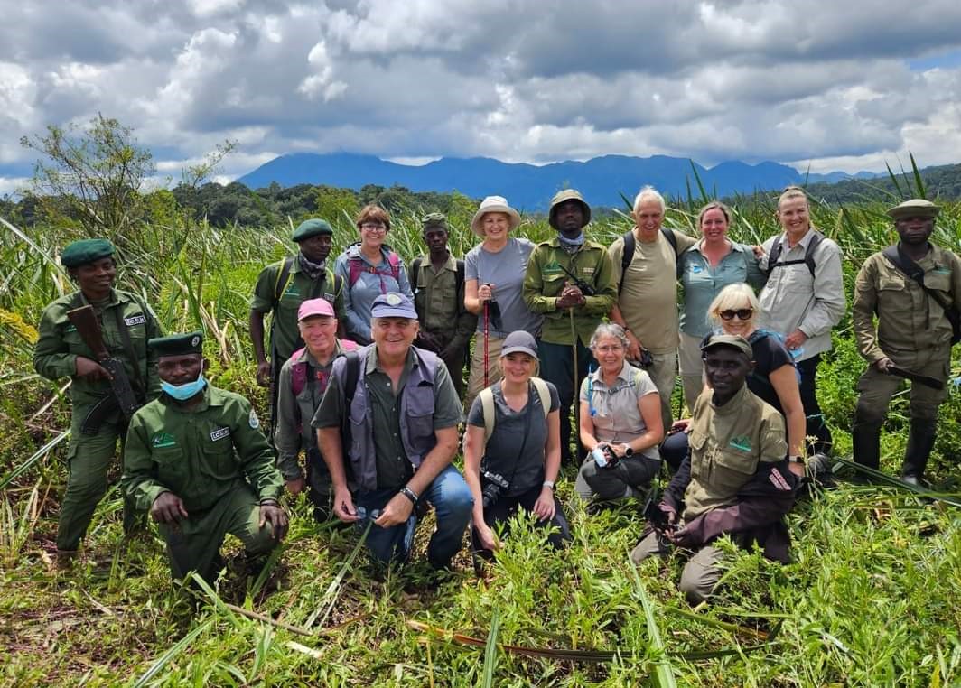 visitors together with park waderns pose for group picture before gorilla trekkking