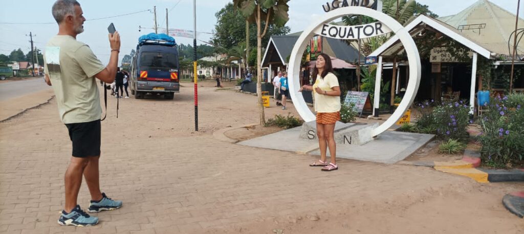 A couple engages in photography at the Equator line at Kayabwe, Uganda