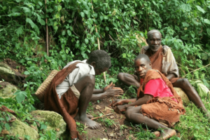 Batwa pygmies people, lighting a fire amidst Bwindi forest bushes